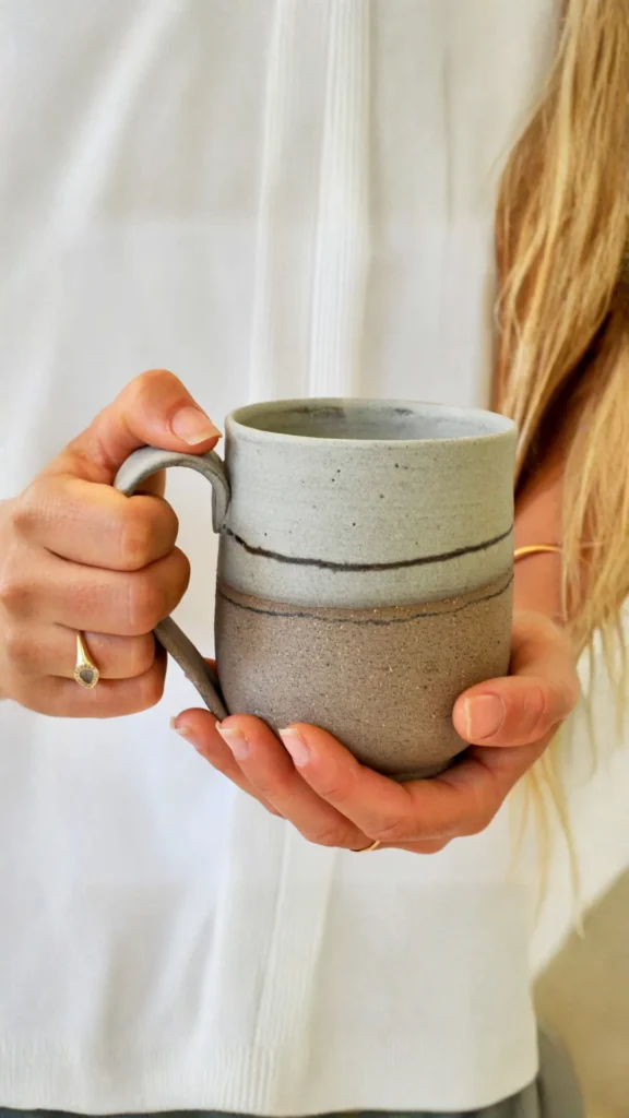 japandi bedside table styling handmade earthy ceramic mug single wildflower stem bedside 2026